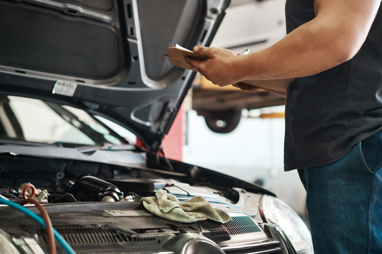 shot of a mechanic holding a clipboard while working in an auto repair shop